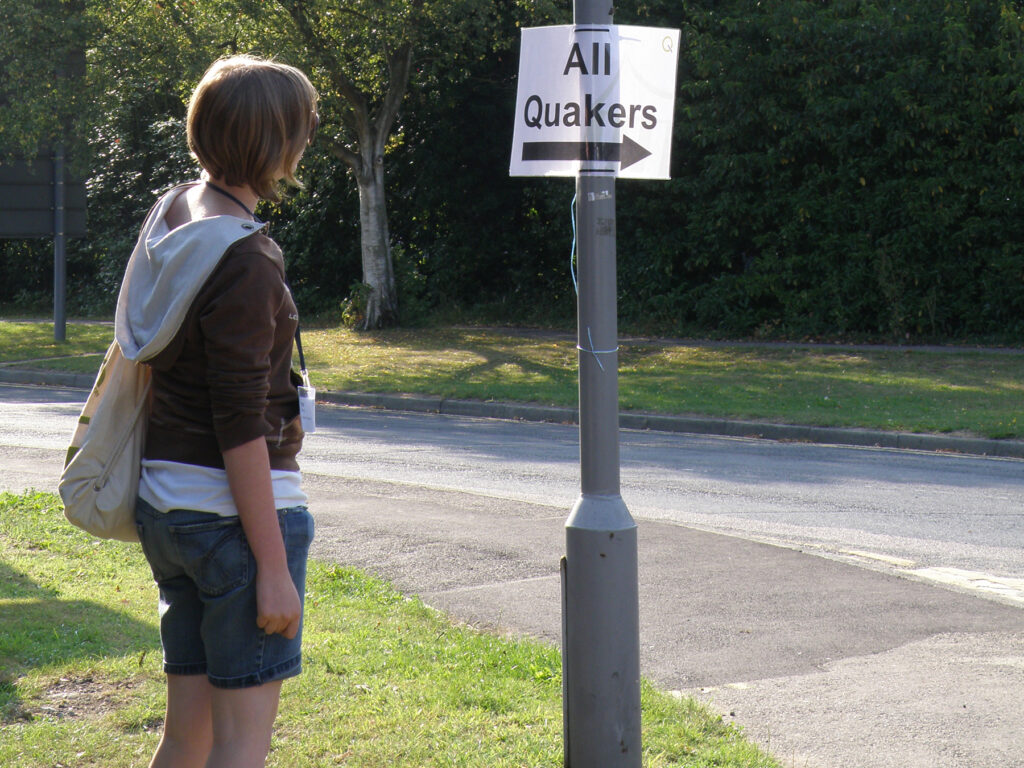 a person reading a sign saying, 'All Quakers' with an arrow.