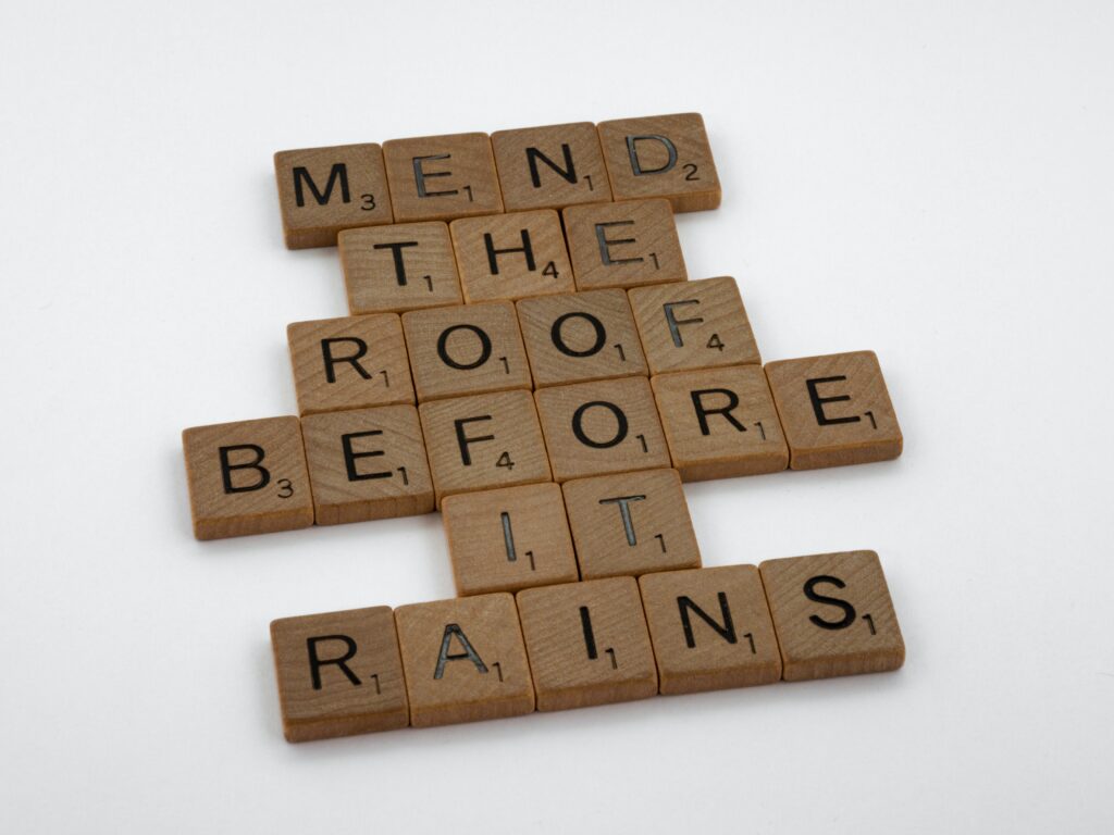 scrabble tiles spelling out, 'mend the roof before it rains'